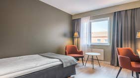 Yhden hengen Standard-huone, jossa oranssit tuolit, ikkuna, valaisimia sekä pöytä, Quality Hotel Grand Kristianstad -hotellissa